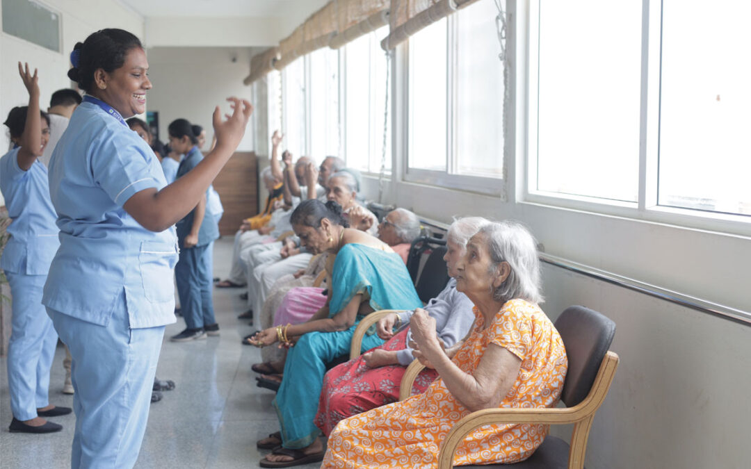 Trained caregiver supporting elderly resident in a senior care center in South India